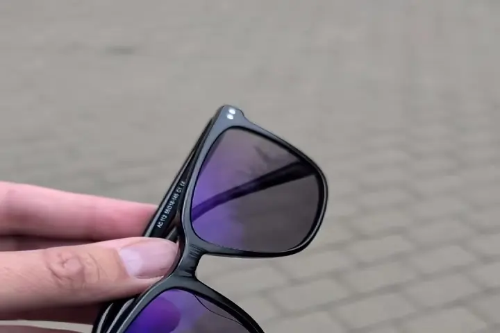 Ochelari cu lentile fotocromatice închise la culoare, afară, în lumina zilei